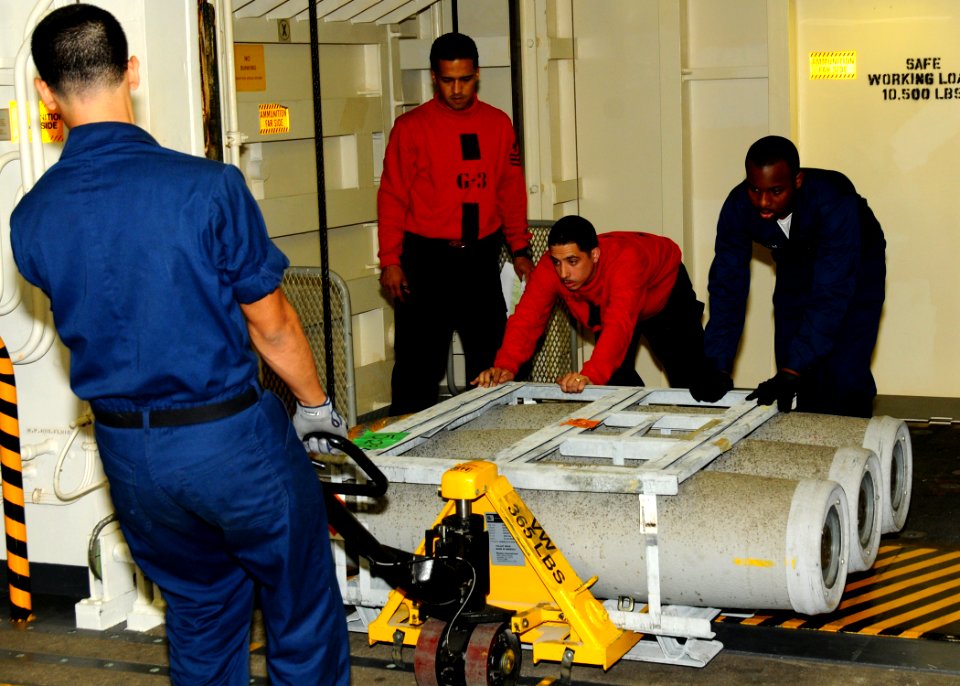 US Navy 100830-N-7908T-179 Sailors assigned to G-5 Division of the weapons department of the aircraft carrier USS George H.W. Bush (CVN 77), move ammunition in the ship's hangar bay