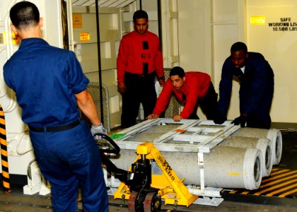 US Navy 100830-N-7908T-179 Sailors assigned to G-5 Division of the weapons department of the aircraft carrier USS George H.W. Bush (CVN 77), move ammunition in the ship's hangar bay