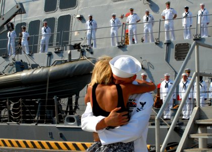US Navy 100901-N-5292M-074 Boatswain's Mate 2nd Class Brandon Carney receives the traditional first kiss from his wife during a homecoming celebration for the guided-missile destroyer USS Cole (DDG 67)