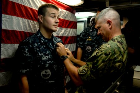 US Navy 100830-N-9818V-626 Master Chief Petty Officer of the Navy (MCPON) Rick West pins the Enlisted Submarine Warfare pin on Electronics Technician 3rd Class Derrick Zulick