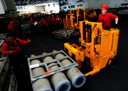 US Navy 100831-N-6632S-051 Sailors assigned to the weapons department aboard the aircraft carrier USS George H.W. Bush (CVN 77) move ordnance in the hangar bay