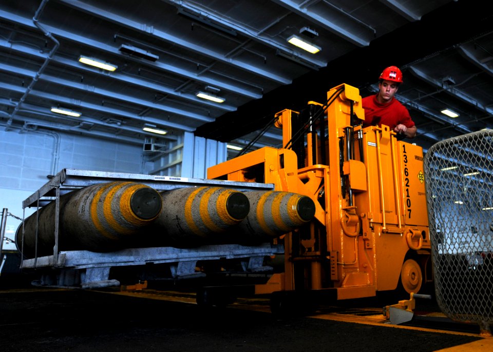 US Navy 100831-N-6632S-129 Sailors assigned to the weapons department aboard the aircraft carrier USS George H.W. Bush (CVN 77) move ordnance in the hangar bay