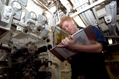 US Navy 100831-N-7191M-007 Engineman 2nd Class Brittany Davidson takes readings from air pressure and temperature gauges in the forward emergency diesel generator space aboard USS George Washington (CVN 73)