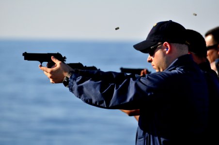 US Navy 100831-N-7293M-048 Hospital Corpsman 1st Class Jason Overly fires a 9mm pistol during live-fire training on the fantail of the amphibious transport dock ship USS Ponce (LPD 15) photo