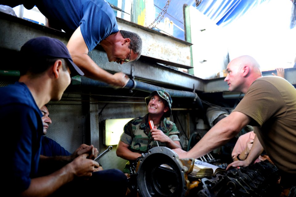 US Navy 100831-N-8546L-384 An engineman from the Costa Rican coast guard hangs over the shoulder of Engineman 1st Class James B. Elgin