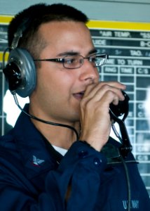 US Navy 100901-N-9950J-303 Operations Specialist 3rd Class Rama Aiyer, from Ann Arbor, Mich., relays the ship's bearing to watch standers as the forward-deployed amphibious assault ship USS Essex (LHD 2) gets underway