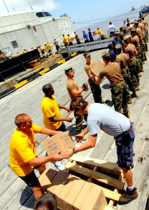 US Navy 100905-N-9643W-175 Sailors, Marines, Airmen and contracted mariners unload 18 pallets of Project Handclasp humanitarian aid supplies to a pier in Guyana photo