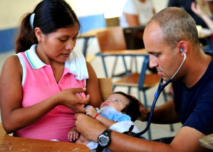 US Navy 100906-N-1531D-004 Lt. Cmdr. Jason Higginson, from Los Angeles, exams an infant during a Continuing Promise 2010 medical civic event photo