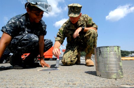 US Navy 100831-N-9818V-571 Master Chief Petty Officer of the Navy (MCPON) Rick West helps Boatswain's Mate Seaman Jennifer Escobar aboard the Ticonderoga-class guided-missile cruiser USS Shiloh (CG 67) photo