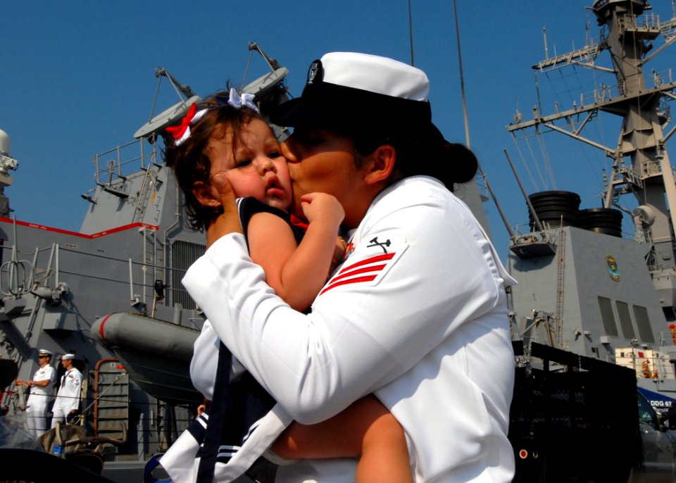 US Navy 100901-N-5292M-106 Damage Control Fireman Anhay Tetreault kisses her daughter during a homecoming celebration for the guided-missile destroyer USS Cole (DDG 67)