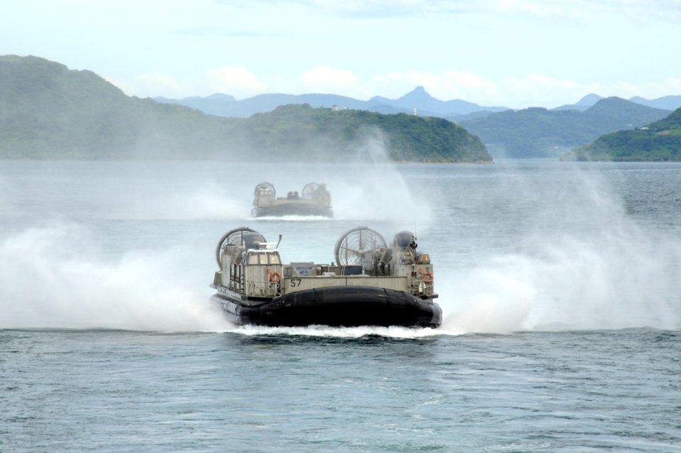 US Navy 100901-N-8335D-411 Landing craft air cushions (LCAC) 57 and LCAC 58, both assigned to Assault Craft Unit (ACU) 5, speed towards the well deck of the amphibious dock landing ship USS Harpers Ferry (LSD 49)