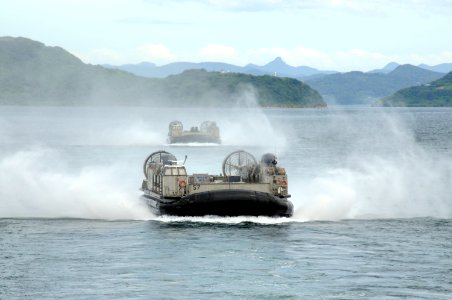 US Navy 100901-N-8335D-411 Landing craft air cushions (LCAC) 57 and LCAC 58, both assigned to Assault Craft Unit (ACU) 5, speed towards the well deck of the amphibious dock landing ship USS Harpers Ferry (LSD 49)