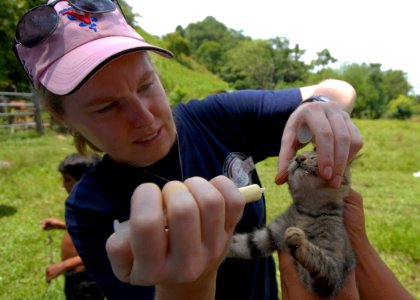 US Navy 100908-N-7680E-211 Elsa Swenson gives a kitten de-worming medication during a veterinary mission