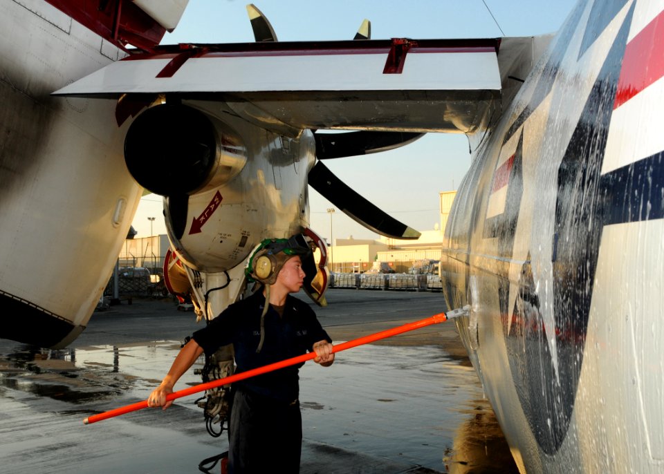 US Navy 100902-N-1092P-784 Aviation Structural Mechanic 3rd Class Bianca Islas ses a wash-stick to clean a C-2A Greyhound during a post-flight wash-down