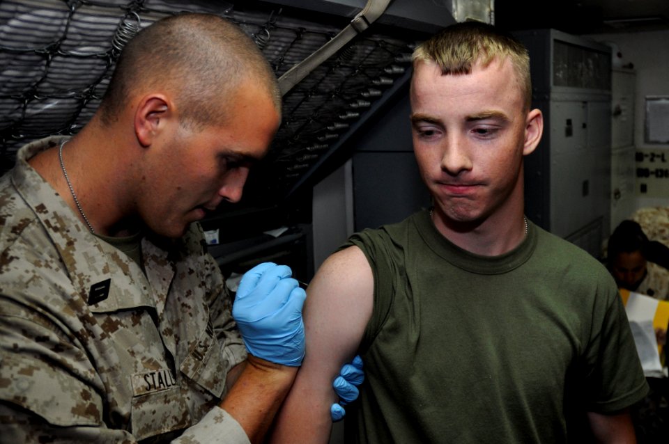 US Navy 100904-N-7293M-038 Lance Cpl. Daniel Breneiser, right, gets vaccinated against smallpox by Hospitalman Nathan Stallfus aboard USS Ponce (LPD 15)