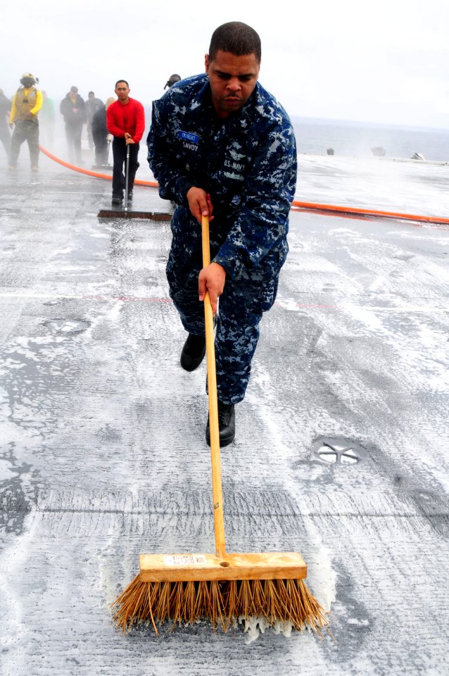 US Navy 100902-N-7488A-874 Chief (Sel.) Aviation Boatswain's Mate (Handling) Shaven Savoy scrubs the flight deck during a scrubbing exercise aboard USS Carl Vinson (CVN 70)
