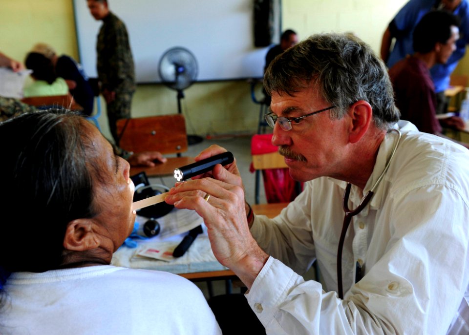 US Navy 100907-N-1531D-184 Dr. Arthur Hayward, a Project Hope volunteer, exams the mouth of a local woman during a Continuing Promise medical civic