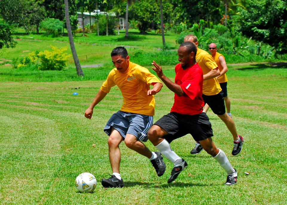 US Navy 100905-N-4044H-129 Hospital Corpsman 1st Class Leo Rodriguez, left, embarked aboard the Royal Australian Navy landing ship heavy HMAS Tobruk (L50), kicks a soccer ball during a community service event