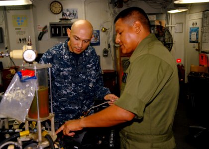 US Navy 100910-N-2218S-025 Staff Sgt. Calvin Chee, right, assigned to Marine Aviation Logistic Maintenance Squad (MALS) 36, explains how to set a p