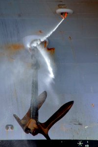 US Navy 100908-N-6720T-035 A Sailor aboard SS George Washington (CVN 73) uses a fire hose to clean mud and debris from one of the ship's 90,000-pou