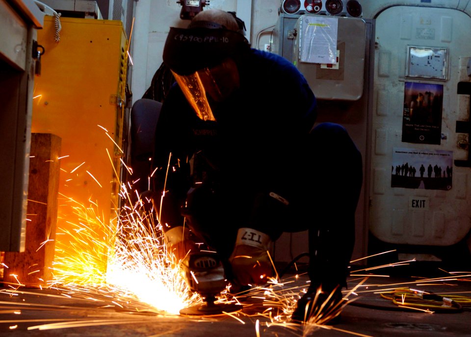 US Navy 100907-N-2908M-021 Aviation Support Equipment Technician Airman Jason Schipper grinds down a protruding surface aboard USS Kearsarge (LHD 3