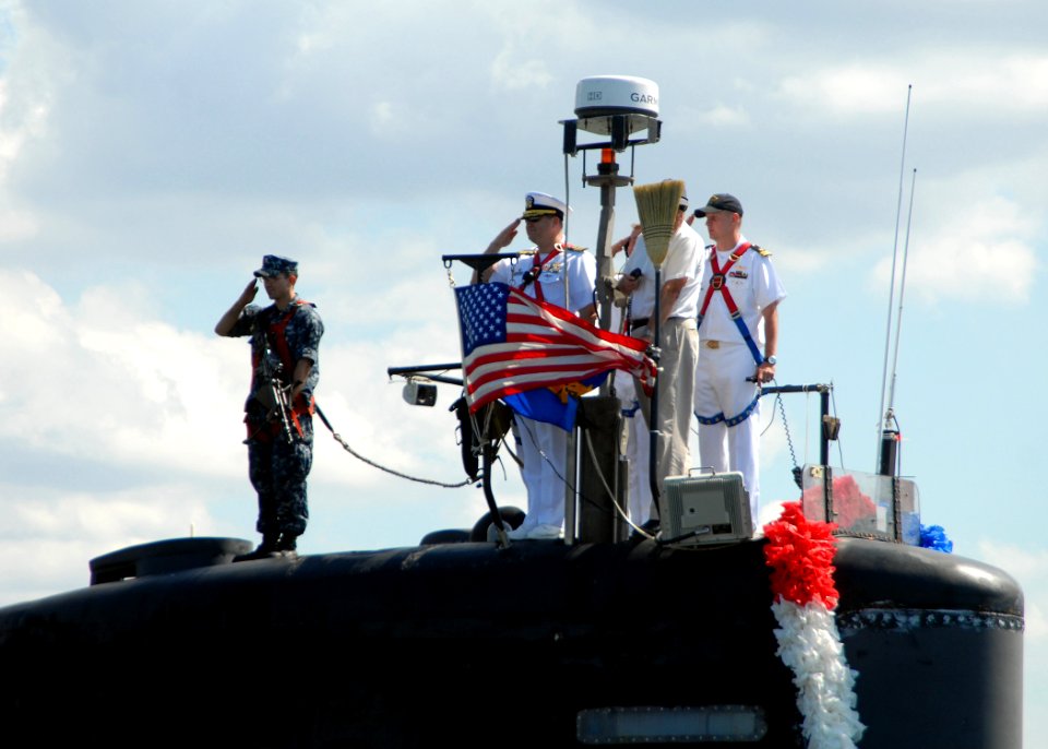 US Navy 100906-N-7705S-050 Cmdr. Douglas Jordan salutes as the ship returns to Naval Station Norfolk following a scheduled six-month deployment