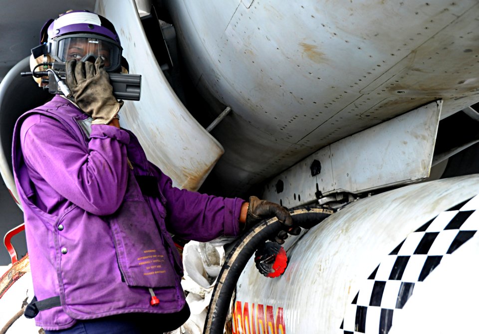 US Navy 100905-N-6427M-026 Aviation Boatswain's Mate (Fuel) Airman Miranda Fitch calls in a status update while de-fueling a drop tank on an F-A 18C Hornet