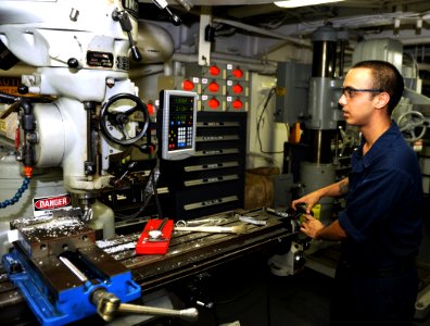 US Navy 100906-N-6362C-058 Machinery Repairman Fireman Mark Mirelez uses a lathe to fabricate a knife edge for a watertight door aboard USS Harry S