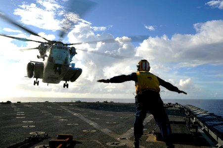 US Navy 100911-N-8335D-960 Boatswain's Mate 2nd Class Salomon Michel directs a CH-53E Super Stallion helicopter aboard the amphibious dock landing photo