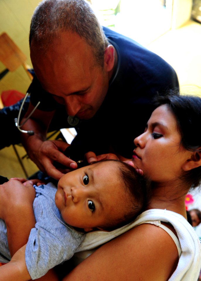 US Navy 100907-N-1531D-169 Lt. Cmdr. Jason Higginson, from Los Angeles, checks the ear of an infant during a Continuing Promise 2010 medical civic