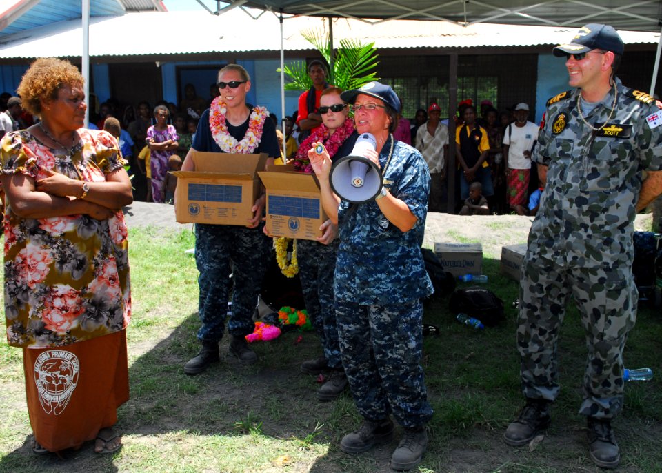 US Navy 100907-N-4044H-320 Capt. Lisa M. Franchetti presents a command coin to Jacobeth Bakut, head teacher of Malaguna Primary School