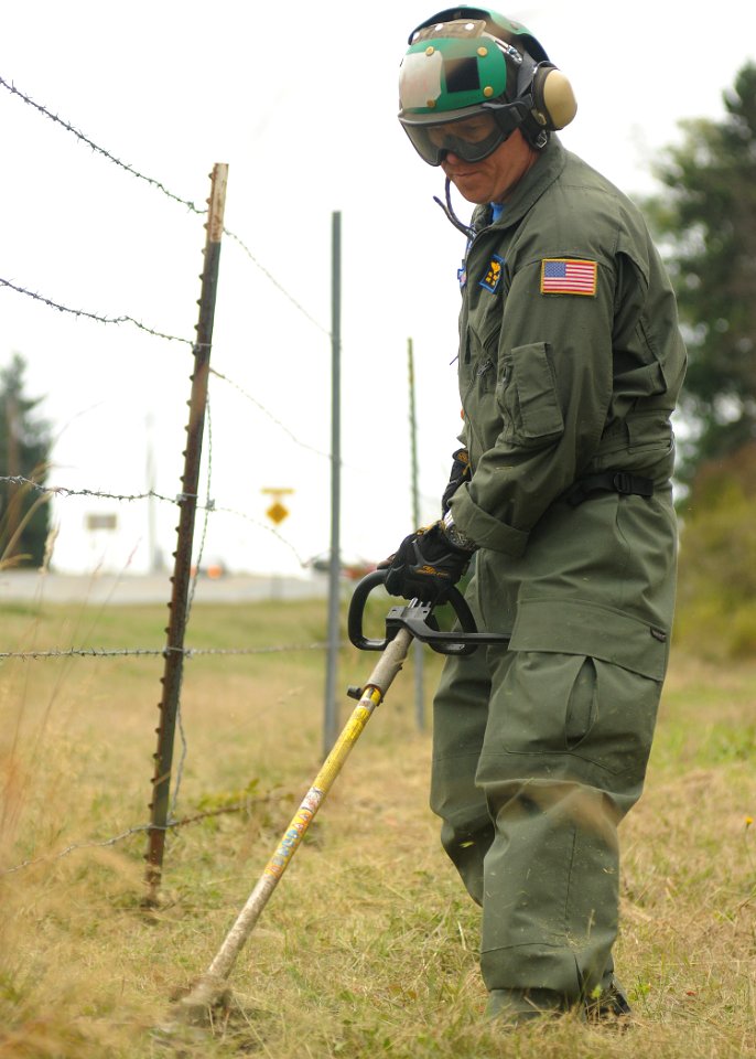 US Navy 100910-N-9520G-007 Chief Naval Air Crewman (Mechanical) (Sel.) Paul Winch uses a string trimmer to cut overgrown grass during the annual cl