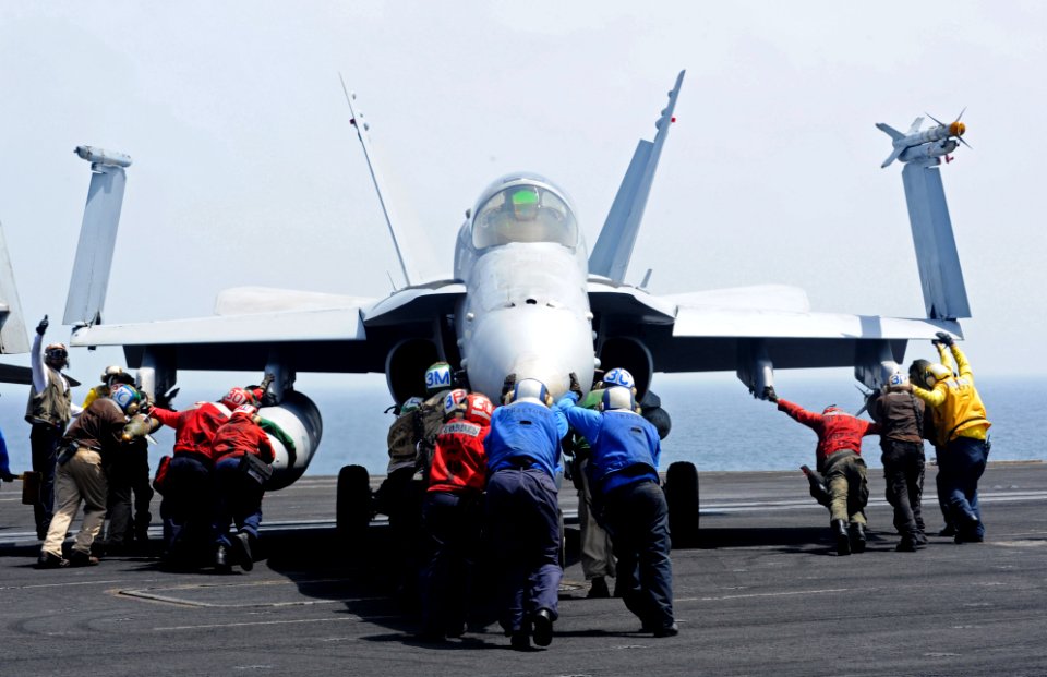 US Navy 100917-N-6362C-080 Sailors and Marines aboard the aircraft carrier USS Harry S. Truman (CVN 75) push an F-A-18C Hornet into a parking posit