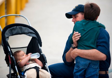 US Navy 100911-N-7981E-071 Chief Quartermaster Jeremy Cornell hugs his sons before deploying aboard the guided-missile cruiser USS Cape St. George