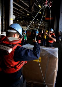 US Navy 100911-N-7103C-059 Seaman Kyle Smith, from Greenville, S.C., helps rig a cargo pallet to a sliding pad-eye during a replenishment at sea wi