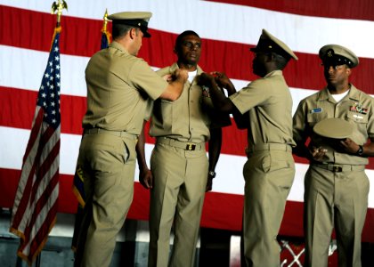 US Navy 100918-N-4973M-046 Chief Aviation Structural Mechanic Equipment Willie Bethea has his chief anchors pinned on his collar by his mentors, Ch