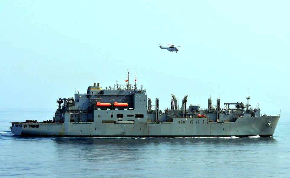 US Navy 100918-N-7948R-174 Puma helicopter flies over the Military Sealift Command dry cargo and ammunition ship USNS Lewis and Clark (T-AKE 1)