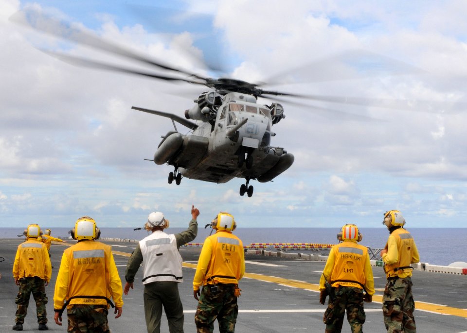 US Navy 100913-N-5538K-205 Flight deck personnel assigned to the forward-deployed amphibious assault ship USS Essex (LHD 2) watch a CH-53E Sea Stal