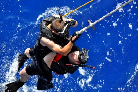 US Navy 100914-N-7293M-042 Lt. j.g. Daniel Cooper and search and rescue swimmer Seaman Apprentice Ryan Owens take turns rescuing an injured swimmer