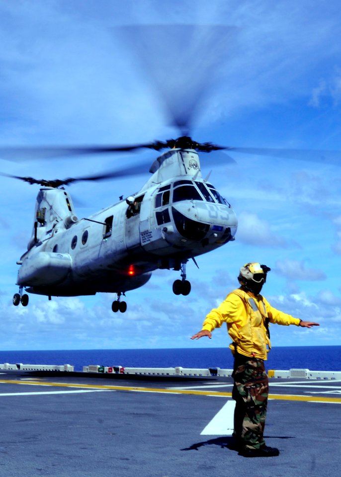 US Navy 100919-N-9950J-450 Aviation Boatswain's Mate (Handling) Airman Bernard Ugalde directs the lift off of a CH-46E Sea Knight helicopter aboard