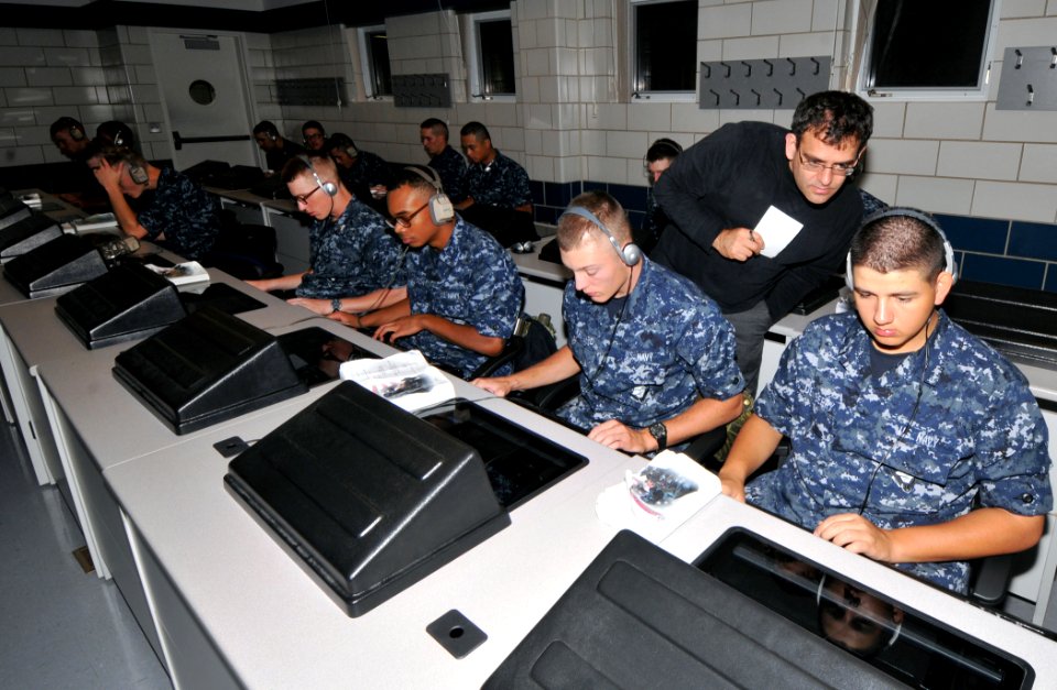 US Navy 100916-N-8848T-351 Dr. Talib Hussain, senior scientist at BBN Technologies, looks over the shoulder of a recruit during a training session