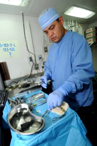 US Navy 100920-N-7191M-036 Hospital Corpsman 1st Class Salvador Lopez, from Coachella Valley, Calif., organizes surgical tools before an oral surge