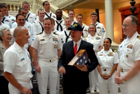 US Navy 101013-N-6736S-066 Georgia Gov. Sonny Perdue, center, is presented a command ball cap by Master Chief Richard Rose