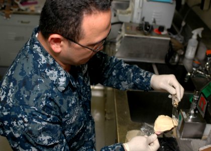 US Navy 101018-N-2918M-027 Hospital Corpsman 2nd Class Gilbert Gutierrez, from Guam, makes a dental mold aboard the aircraft carrier USS Nimitz (CV photo