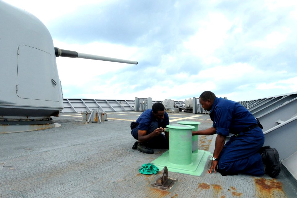 US Navy 101019-N-6632S-416 Sailors apply primer to bits on the ship's deck