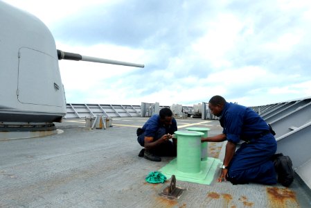 US Navy 101019-N-6632S-416 Sailors apply primer to bits on the ship's deck