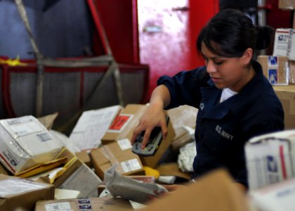 US Navy 101014-N-2013O-045 Operations Specialist Seaman Crystal Garcia, from Dallas, scans mail in the hangar bay of the aircraft carrier USS Georg