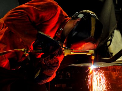 US Navy 101013-N-7948R-257 Hull Technician Fireman Tristan Reynolds arc-welds a flange aboard the amphibious dock landing ship USS Pearl Harbor (LS