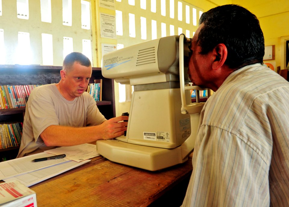 US Navy 101019-N-1531D-054 Air Force Master Sgt. Breck Downey uses a auto-refractive keratometer to determine an eye prescription during a Continui
