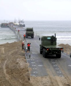 US Navy 101017-N-1786N-148 Sailors assigned to Amphibious Construction Battalion (ACB) 1 load civil engineer support equipment onto a floating caus